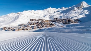 Un pueblo de montaña cubierto de nieve, con edificios dispuestos en niveles.