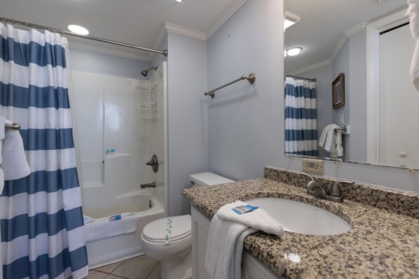 A bathroom with a shower, toilet, and sink.