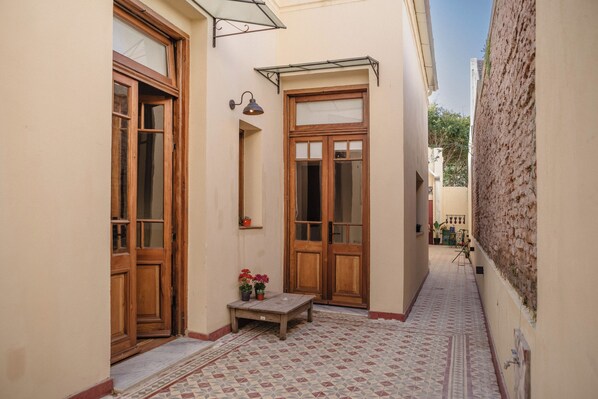 A narrow alleyway with wooden doors and a tiled floor. - La Noire Petit Hotel (Buenos Aires)