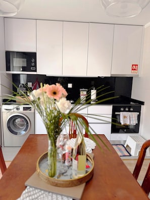 A modern kitchen with a microwave, oven, and washing machine. - Ribeiro House (Lourinhã)