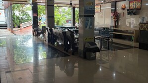 A spacious lobby with a glass partition, seating area, and a reception desk. - Chinatown hotel (Caye Caulker)