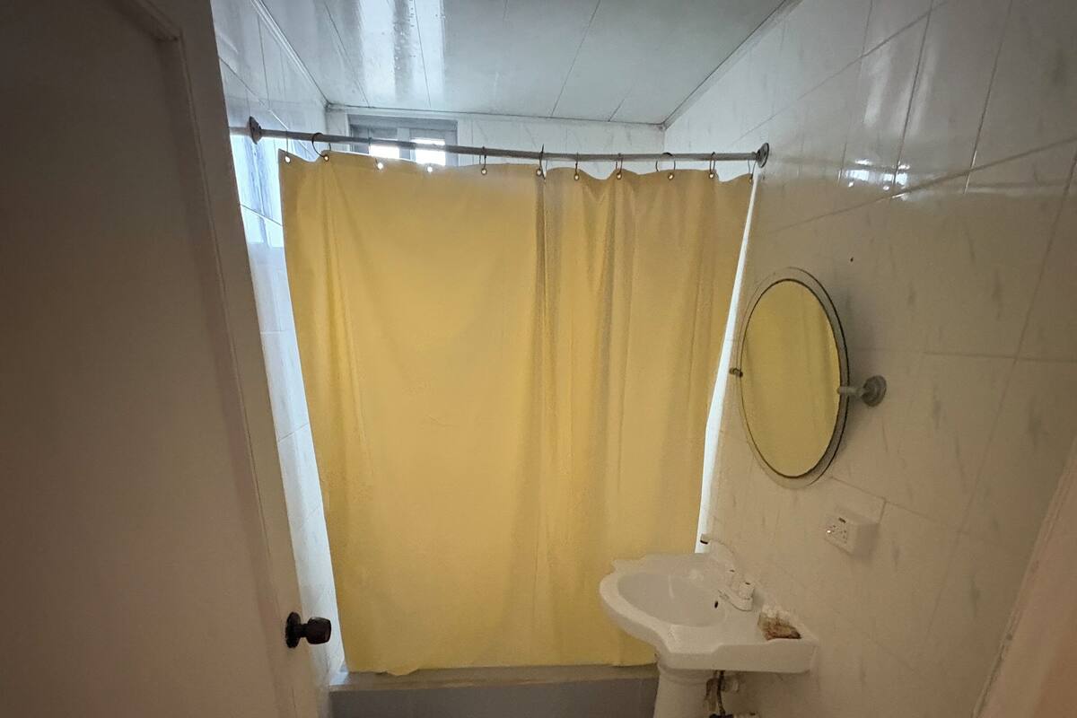 A bathroom with a toilet, sink, and shower curtain.