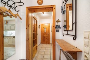 A hallway with wooden doors, a radiator, and a wooden bench. - Apartment 'Ferienwohnung Nord-West' with Private Garden and Wi-Fi (Pellworm)