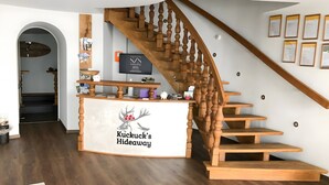 Una scala di legno con un cartello che riporta 'Kuckuck's Hideaway' e una reception.