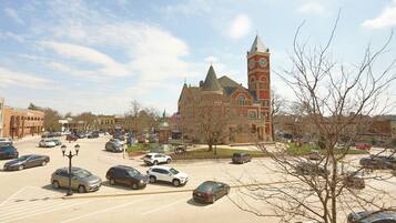 A parking lot with cars and a historic building with a clock tower in the background.