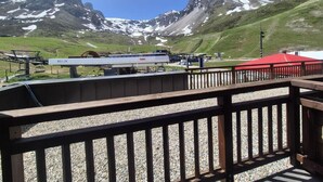 Bergzicht vanaf een houten terras, met een skilift op de achtergrond.