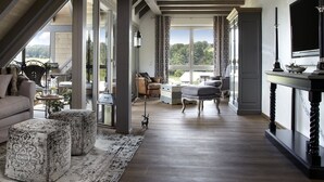 A spacious living area with a high ceiling, large windows, a fireplace, and a view of the outdoors. - Apartment 'Halali' with Spa Area and Mountain View (Ibach)