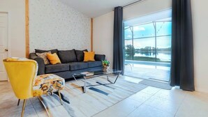 A modern living room with a sofa, a yellow armchair, and a glass coffee table.