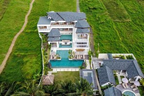 A large, multi-story house with a swimming pool, surrounded by lush greenery. - Villa Baia by BaliSuperHost (Bali)