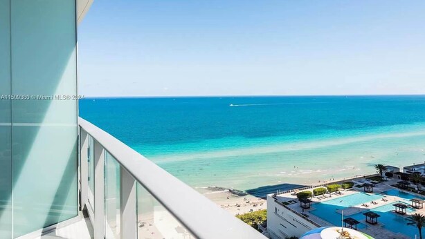 A view from a balcony overlooking a beach with a pool and lounge area. - Beautiful Hyde Resort Luxe 2BR Private Beachfront (Hollywood)