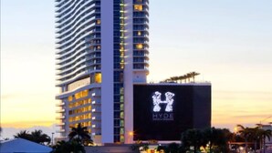 A tall, modern hotel with a distinctive wavy facade and illuminated windows. - Beautiful Hyde Resort Luxe 2BR Private Beachfront (Hollywood)
