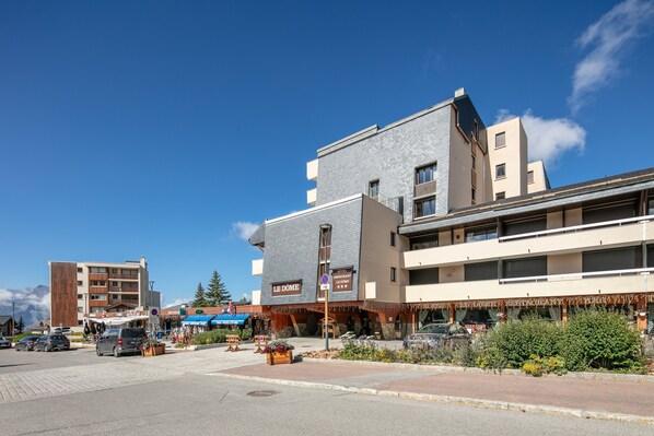 A hotel with a sign reading "LE DOME" and a restaurant below.