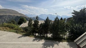 A paved area with a view of distant mountains, a street lamp, and some trees. - 300m from ski lifts, 1st floor, balcony, tv, ski locker, 28m², Alpe d'Huez (L'Alpe d'Huez)