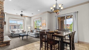 A spacious living room with a fireplace, a dining area with a large table and chairs, and a balcony with a view. - The Overlook at Coral Springs (Hurricane)