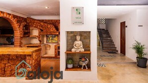 A modern interior with a stone archway, a statue, and a staircase leading to another level.