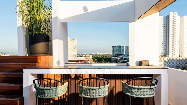 A modern outdoor seating area with a view of the city skyline.