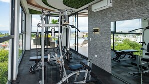 Una palestra con attrezzature per esercizi, ampie finestre e vista sull'esterno.