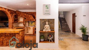 A modern interior with a stone archway, a Buddha statue, and a staircase leading to another level. - Strategically located suite with desk (Cancún)