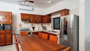 A kitchen with wooden cabinets, a stainless steel refrigerator, a microwave, and a stove. - Villa for groups in excellent location (Playa del Carmen)