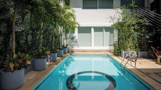 An indoor swimming pool with a circular design, surrounded by potted plants and a staircase. - Magnificent 2 blocks from the beach and 5th Ave. (Playa del Carmen)