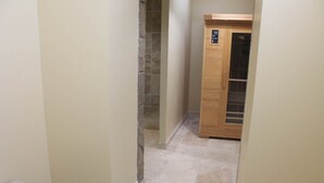 Un couloir étroit avec une armoire en bois et un sol carrelé.
