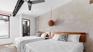 Habitación de hotel con dos camas, un ventilador de techo, una lámpara colgante de mimbre y vista al exterior.