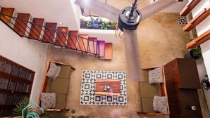 Un área de spa con bancos de madera, un muro con diseño y una escalera.