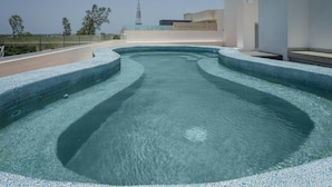 A rooftop swimming pool with a clear view of the surrounding buildings and landscape. - Charming with modern design (Cancún)