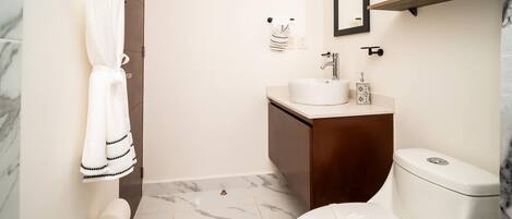 Une salle de bain équipée de toilettes, d’un lavabo et d’un porte-serviettes.