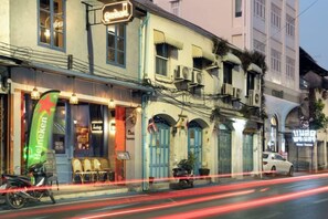 A building with a restaurant on the ground floor, a signboard, and a parked motorcycle. - Swing By (Bangkok)