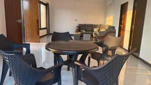 A modern dining area with a round table and six wicker chairs. - "Kanchan Kutir villa" A Serene Escape in the Heart of Udaipur" (Udaipur)