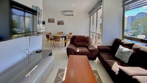 A modern living room with a sofa, a coffee table, and a dining area with chairs and a table. - Cozy Gym-Pool-3 floors (Cancún)