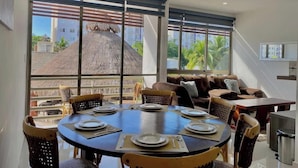 A dining area with a round table set for four, surrounded by wicker chairs. - Cozy Gym-Pool-3 floors (Cancún)
