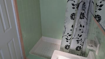 Habitación económica, vistas a la playa | Baño | Ducha, artículos de higiene personal gratuitos y papel higiénico