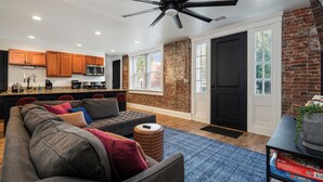 A modern living room with a sectional sofa, a coffee table, and a ceiling fan.