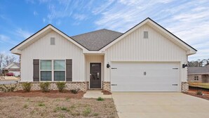A single-story house with a garage, a front door, and a small front yard. - Entire 4 Bedroom home in Pearl, Mississippi (Pearl)