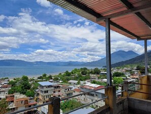 Un pueblo costero con edificios, vista al mar y montañas al fondo.