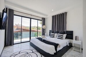 Un dormitorio moderno con una cama grande, una mesita de noche y vistas al exterior.