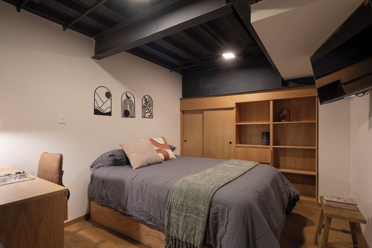 Escritorio, cortinas blackout y tabla de planchar con plancha