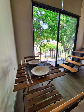A dining area with a table set for two, a glass of water, and a metal fork. - Lofts La Paz (Guadalajara)