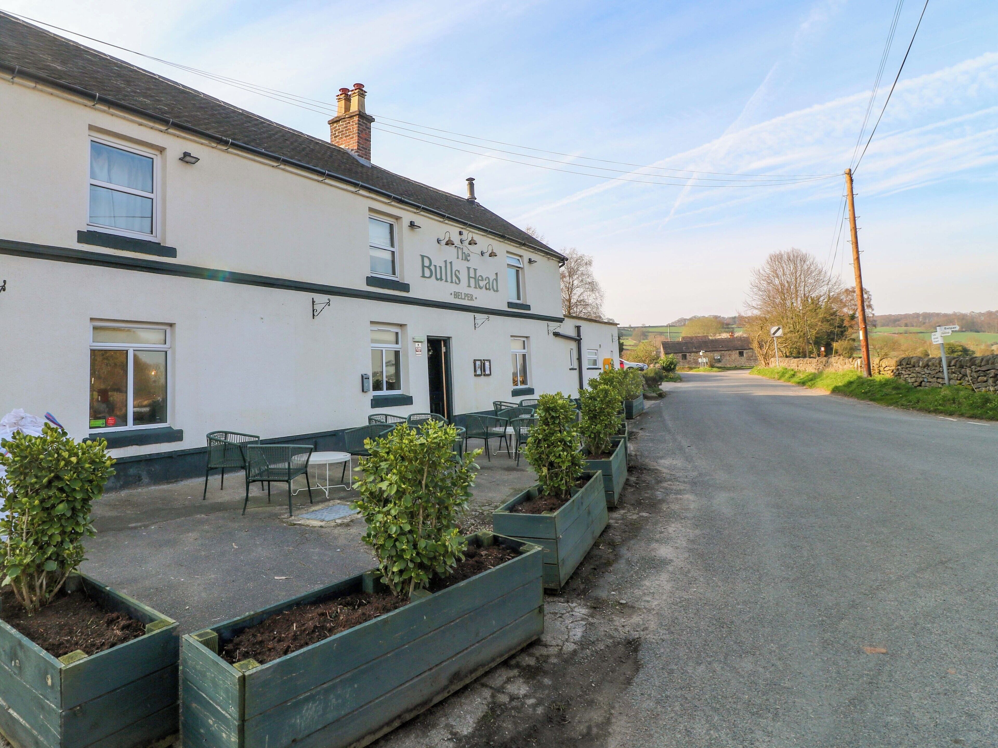 A building named 'The Bulls Head' with outdoor seating and planters.