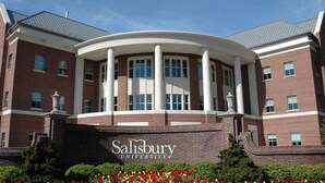 Um edifício de tijolos com uma estrutura circular central, colunas e uma placa com a inscrição 'Salisbury University'.
