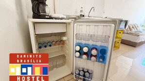 A kitchenette with a coffee maker, a water dispenser, and a fridge stocked with beverages.