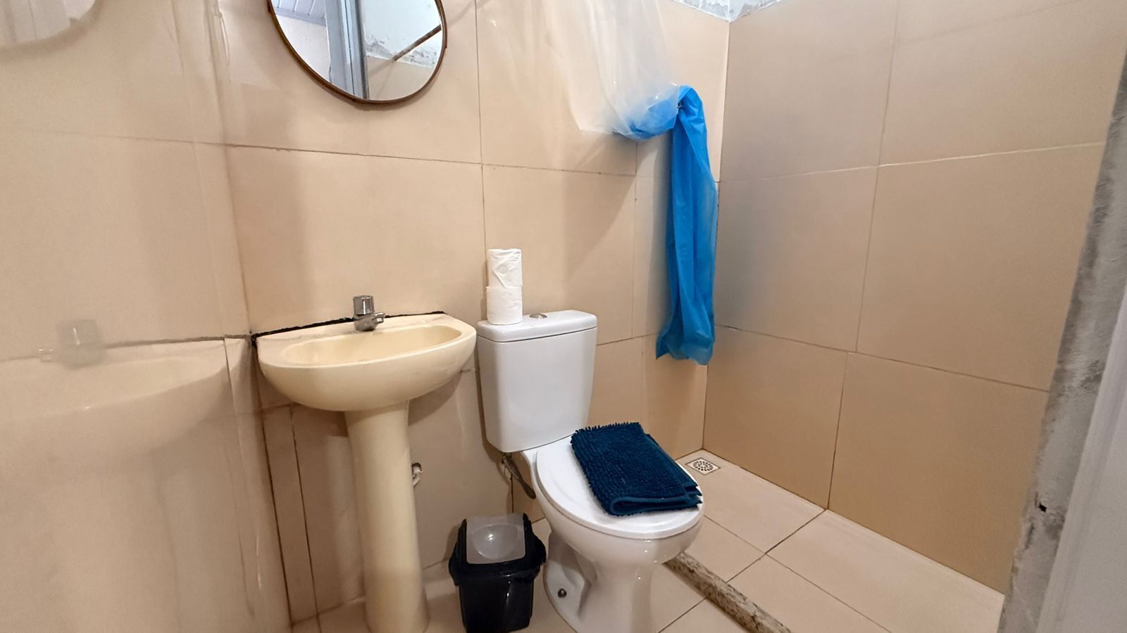 Un baño con lavamanos, inodoro y un espejo en la pared.