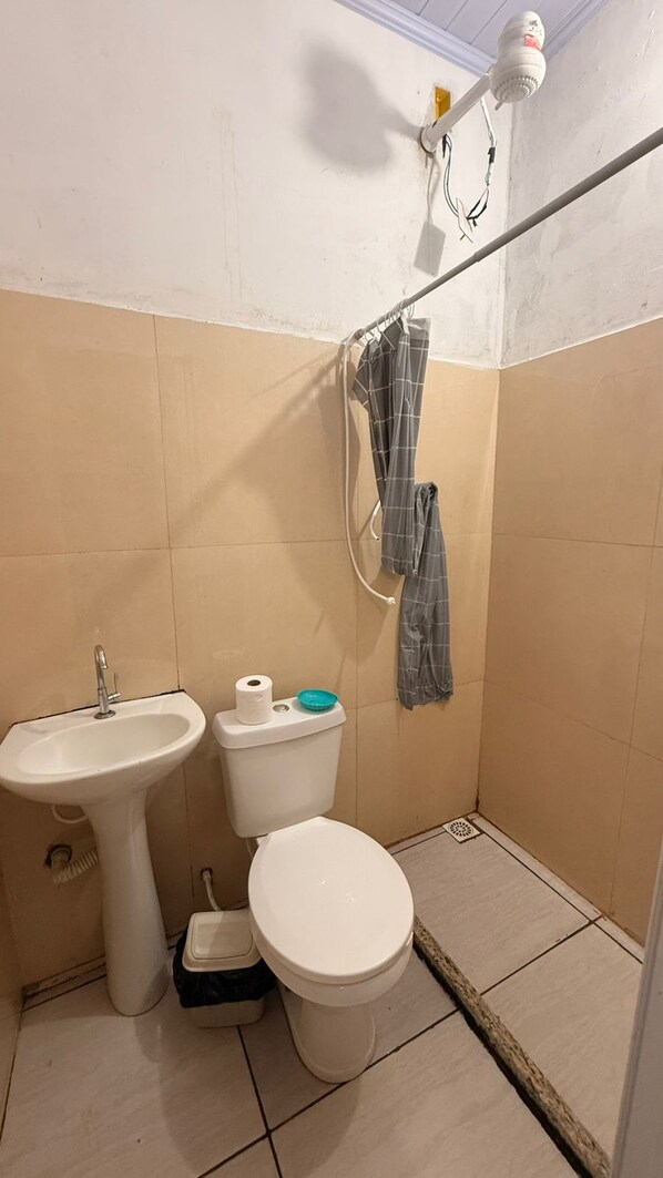 Un bagno piccolo con lavandino, WC e doccia.