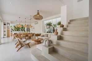 Un interior moderno con una escalera, comedor y cocina.