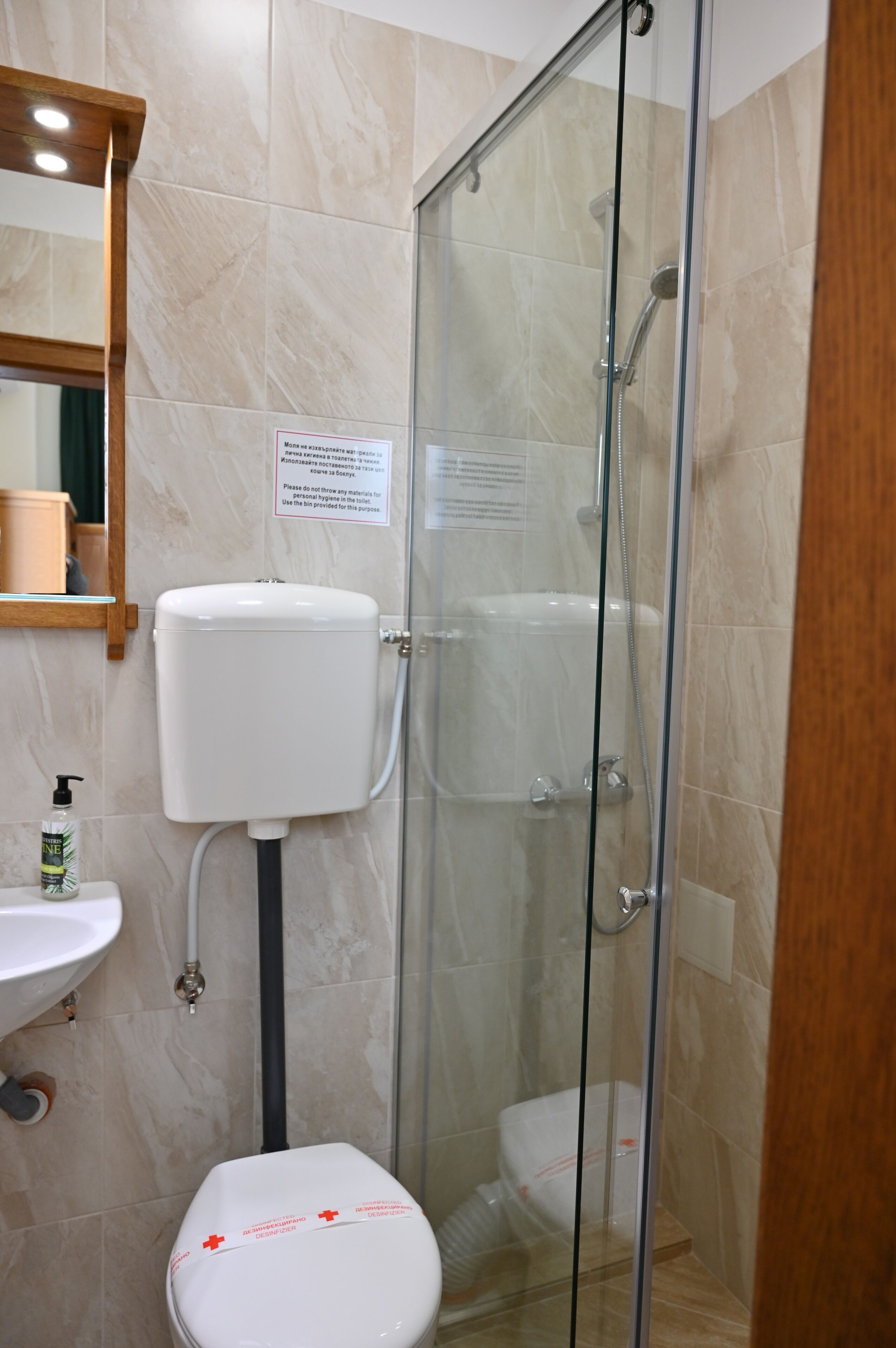 Une salle de bain avec une douche à parois de verre, des toilettes et un lavabo.