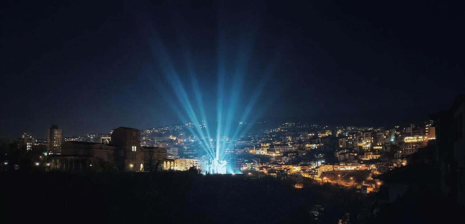 Un paisatge urbà nocturn amb edificis i una il·luminació destacada.