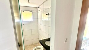 A small, compact bathroom with a toilet, sink, and shower. - Residencial Gomes (Goiânia)