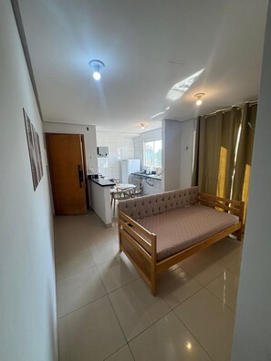 A compact living space with a bed, kitchenette, and a dining area. - Residencial Gomes (Goiânia)